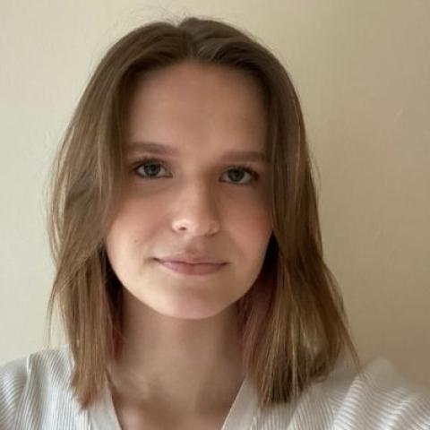 Katarzyna, a young female wearing white jumper with brown should length hair
