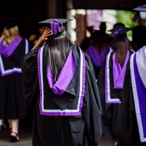 group of students walking in graduation dress