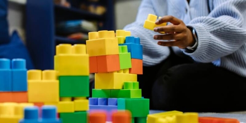 Someone building a tower with plastic toy blocks