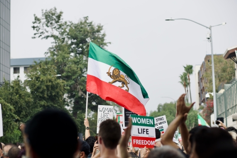 Group of people holding signs and Iranian flag - Photo by Craig Melville on Unsplash