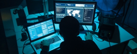 Computer hacker working at laptop