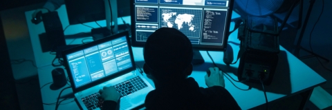Computer hacker working at laptop