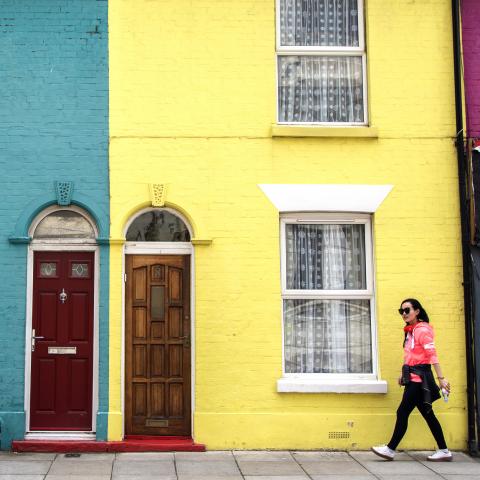 Student walking down Southsea street past colouful houses