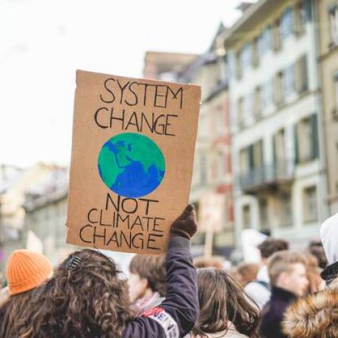 Climate change protestor holding sign with earth on it