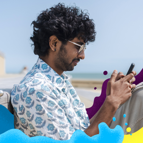 Man using his phone on the beach 