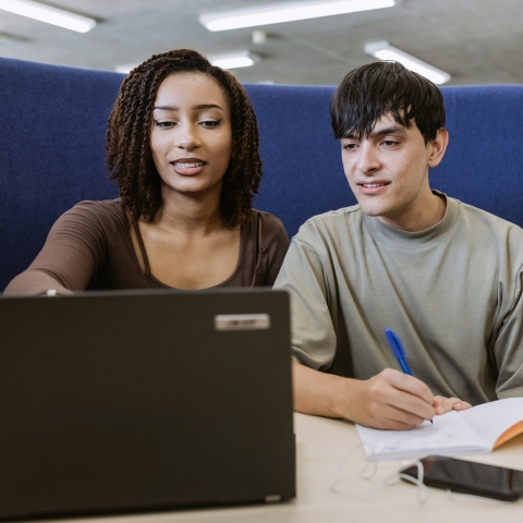 Two people looking at a laptop screen.