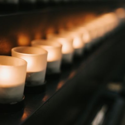 A row of small tealight candles, set up as a memorial