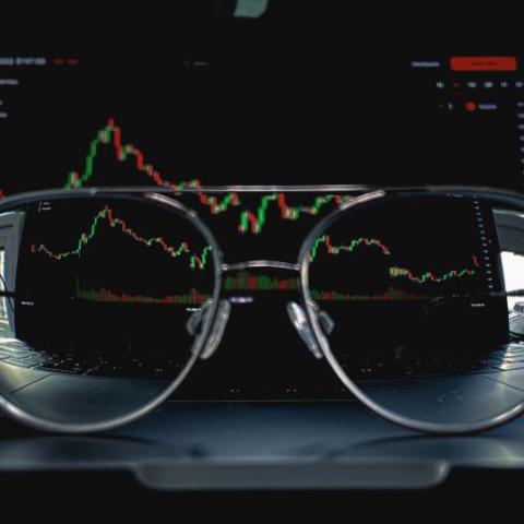 A pair of glasses in front of a financial analysis
