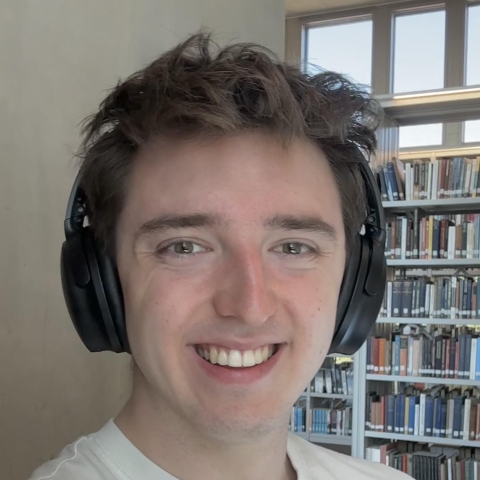 Student smiling and wearing headphones.