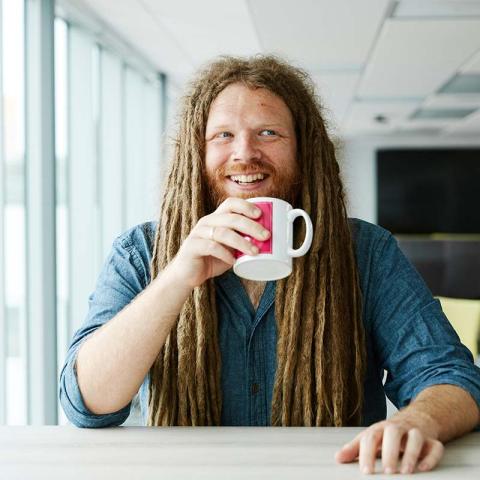 Mathematician Dr Jamie Foster holding a cup of coffee