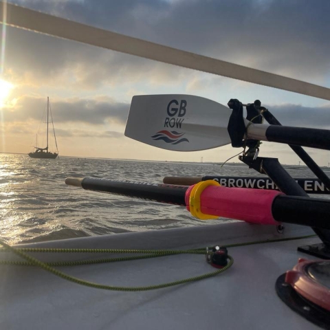 A sunset at sea with a GB Row Challenge oar in the foreground