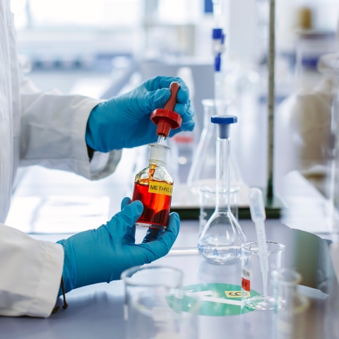 Hands holding a vial in a lab