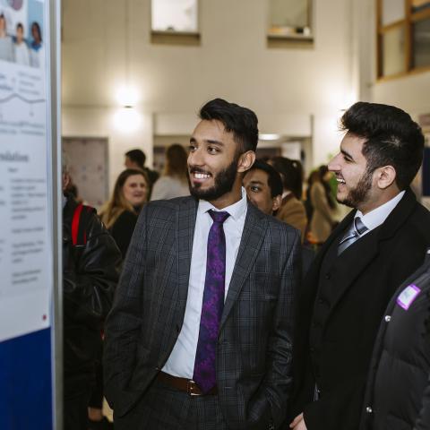 Male student looking at a board at conference