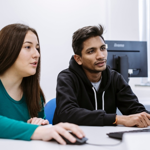 two students looking at a computer screen