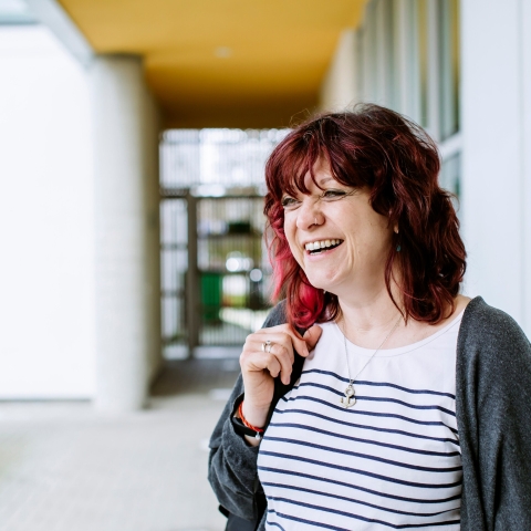 Headshot of woman with red hair stood outside of UoP building