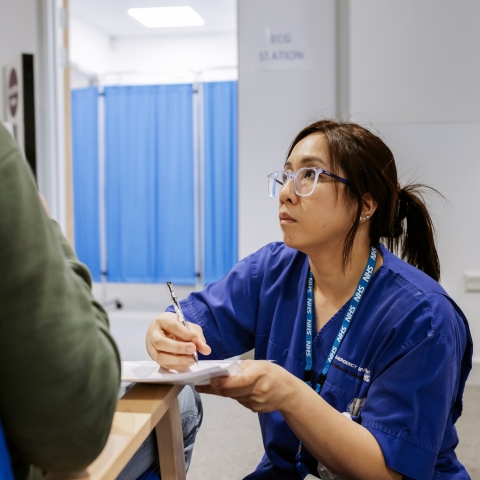 NHS worker writing notes