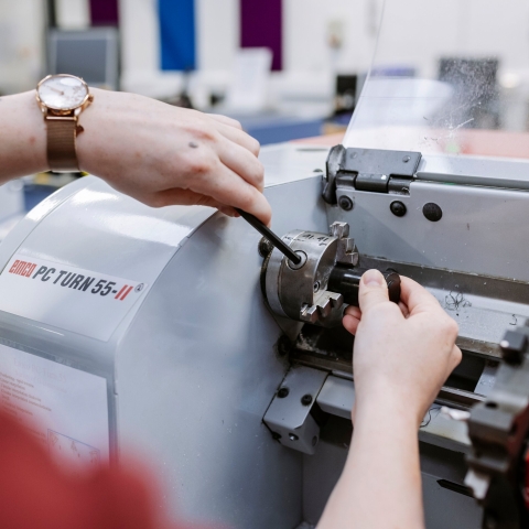 Female student making manual adjustments on large machine.
Technology Facilities Day One - NOT FOR THIRD PARTY - CONSENT