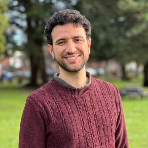 Global Recruitment officer Guiliano looking at the camera with trees in the background