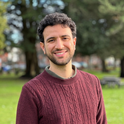 Global Recruitment officer Guiliano looking at the camera with trees in the background