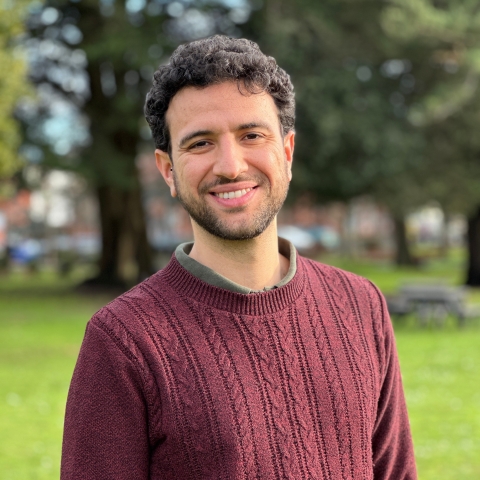Global Recruitment officer Guiliano looking at the camera with trees in the background