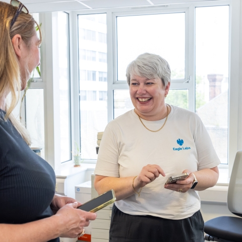 Two women smiling whilst speaking to each other