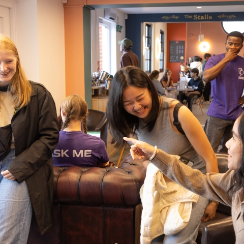 International students are chatting and laughing in a café.