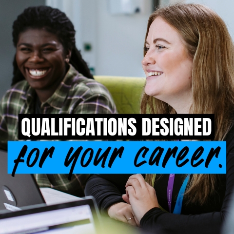 Two postgraduate students sitting at a desk with a laptop