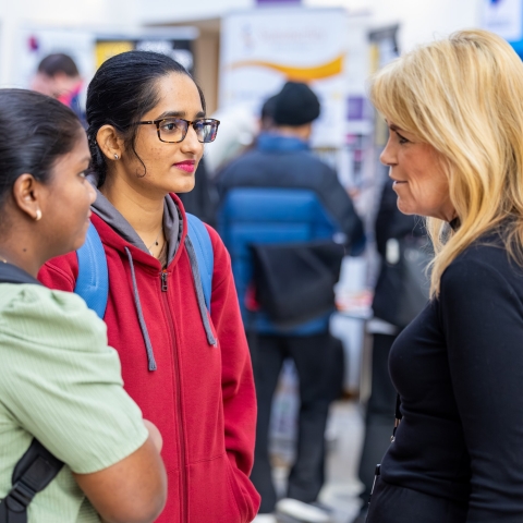 Two students and an adviser at a careers fair
