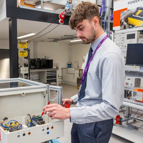 Male lecturer in the engineering lab using equipment