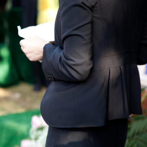 Person dressed in black holding a piece of paper 