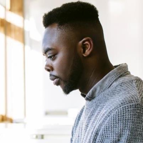 A postgraduate student studying at a library desk