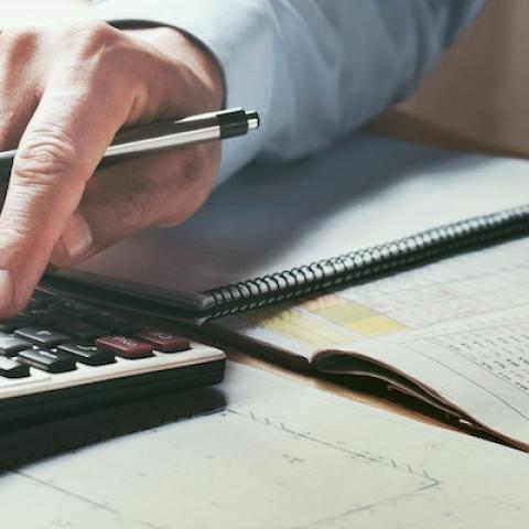 Man checking financial figures on calculator
