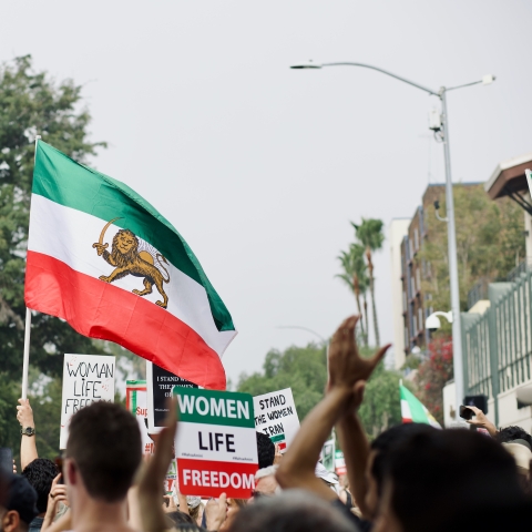 Group of people holding signs and Iranian flag - Photo by Craig Melville on Unsplash