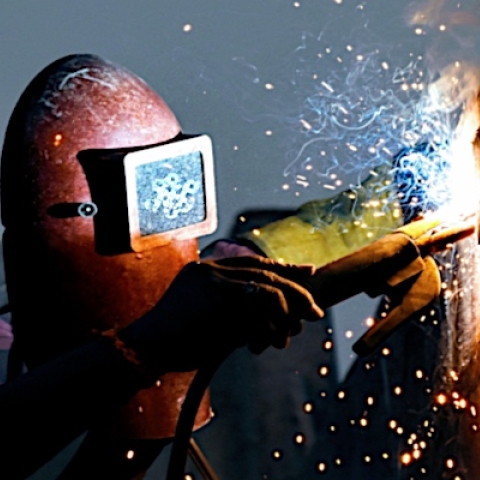 A person in a welding helmet welding