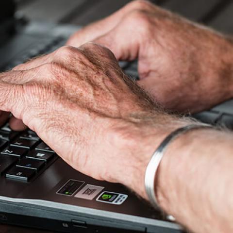 A pair of hands typing on a laptop keyboard
