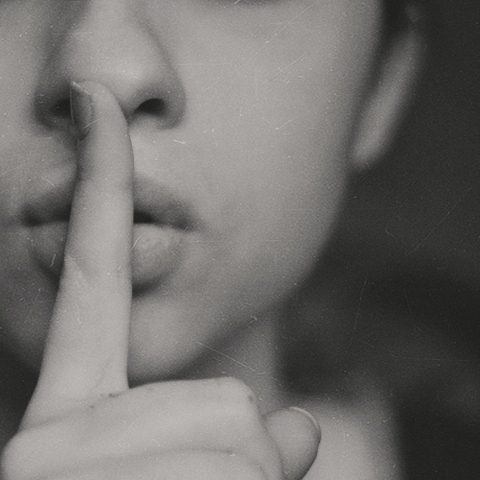 Person holding hush sign with finger over mouth - Photo by Kristina Flour on Unsplash