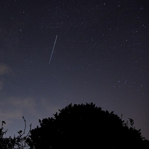 A picture of a night sky with a shooting star