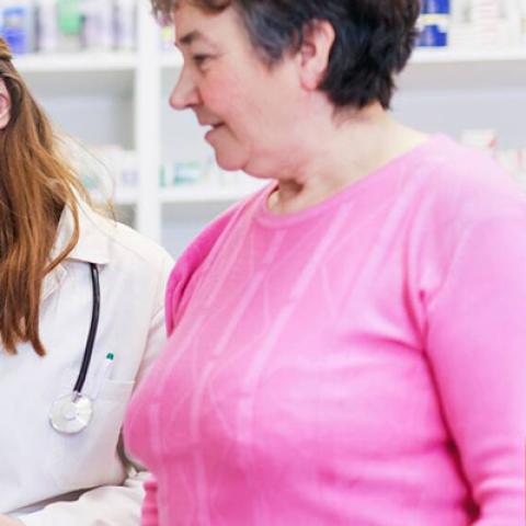 A pharmacist advising a female patient on medicine in a pharmacy