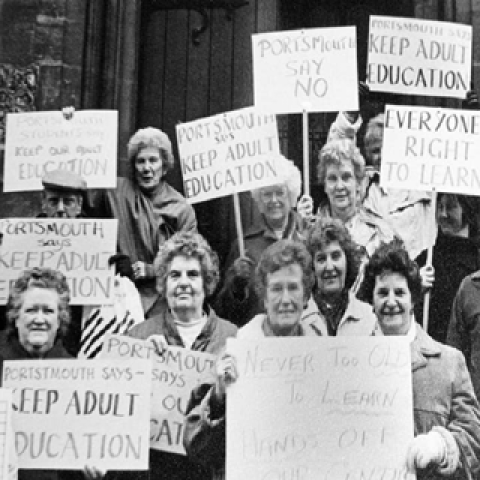 a group of women holding placards 