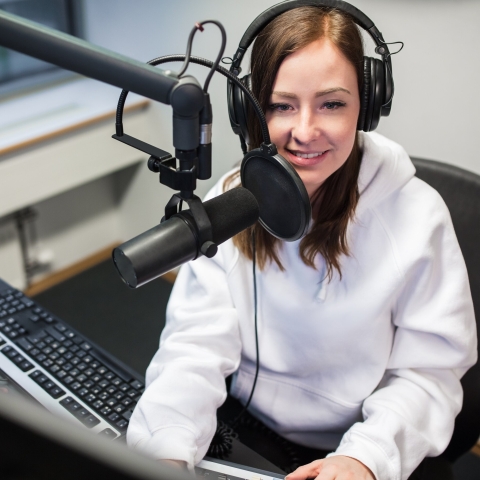 A student in a recording studio wearing headphones