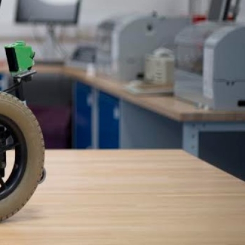 A powered wheelchair fitted with sensors on a work bench in an engineering lab