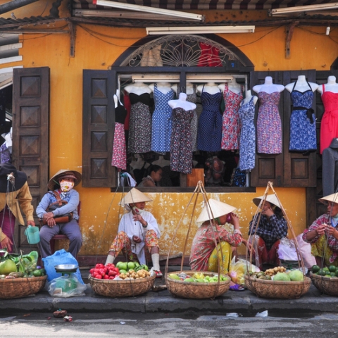 Asian women sitting on the floor at a market
