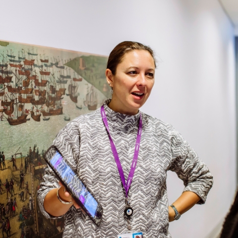 Female employee talking about history, holding a tablet