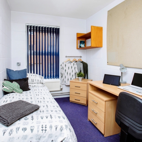 A bedroom in Bateson student halls with a bed, desk, and chair