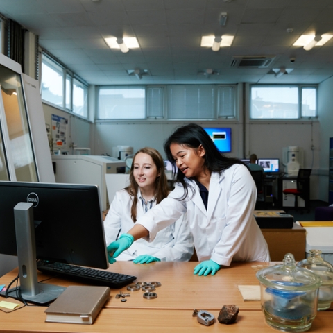 Researchers in lab coats with computer and equipment