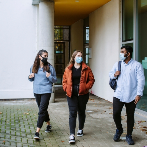Students in masks walking on campus