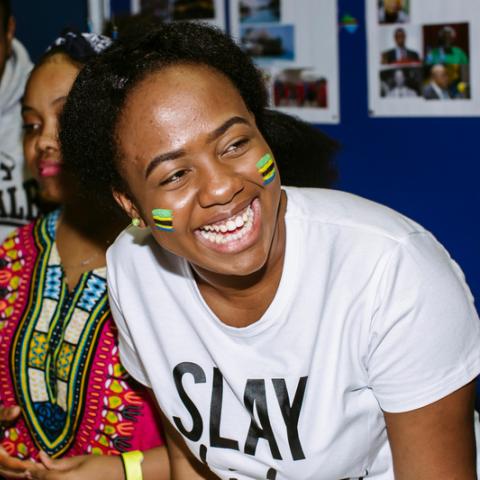 Student smiling, she has Tanzanian flags painted on her cheeks