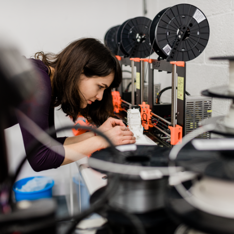 A woman using a 3D printer