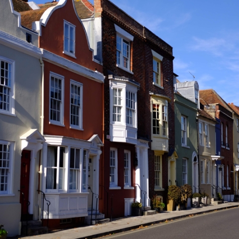 row of georgian style houses on a street with spinnaker tower in the background