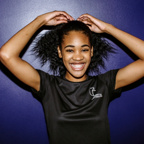 Smiling student in black sport tops, lifting arms
